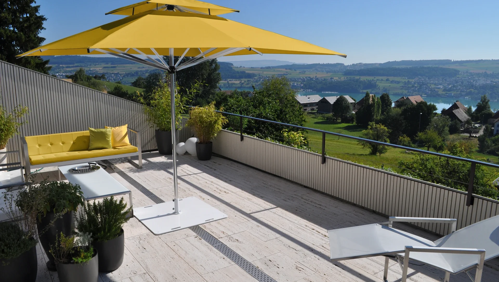 Moderne Terrasse mit gelbem Sonnenschirm und Panoramablick