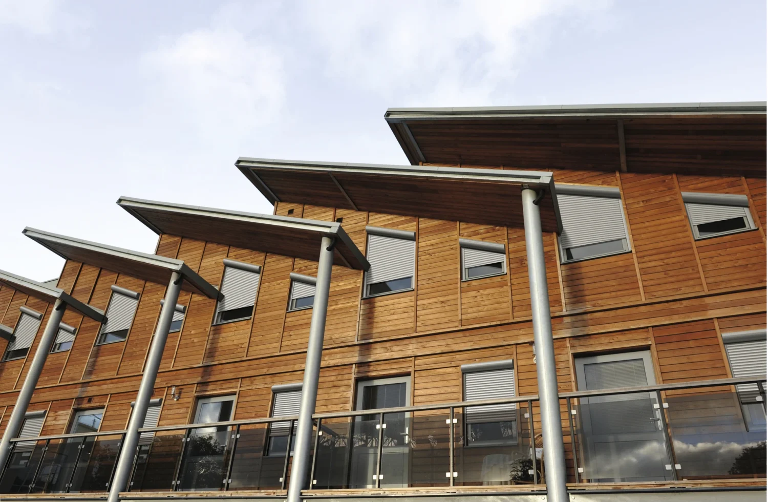 Moderne Holzhausfassade mit großen Fenstern und Überdachungen