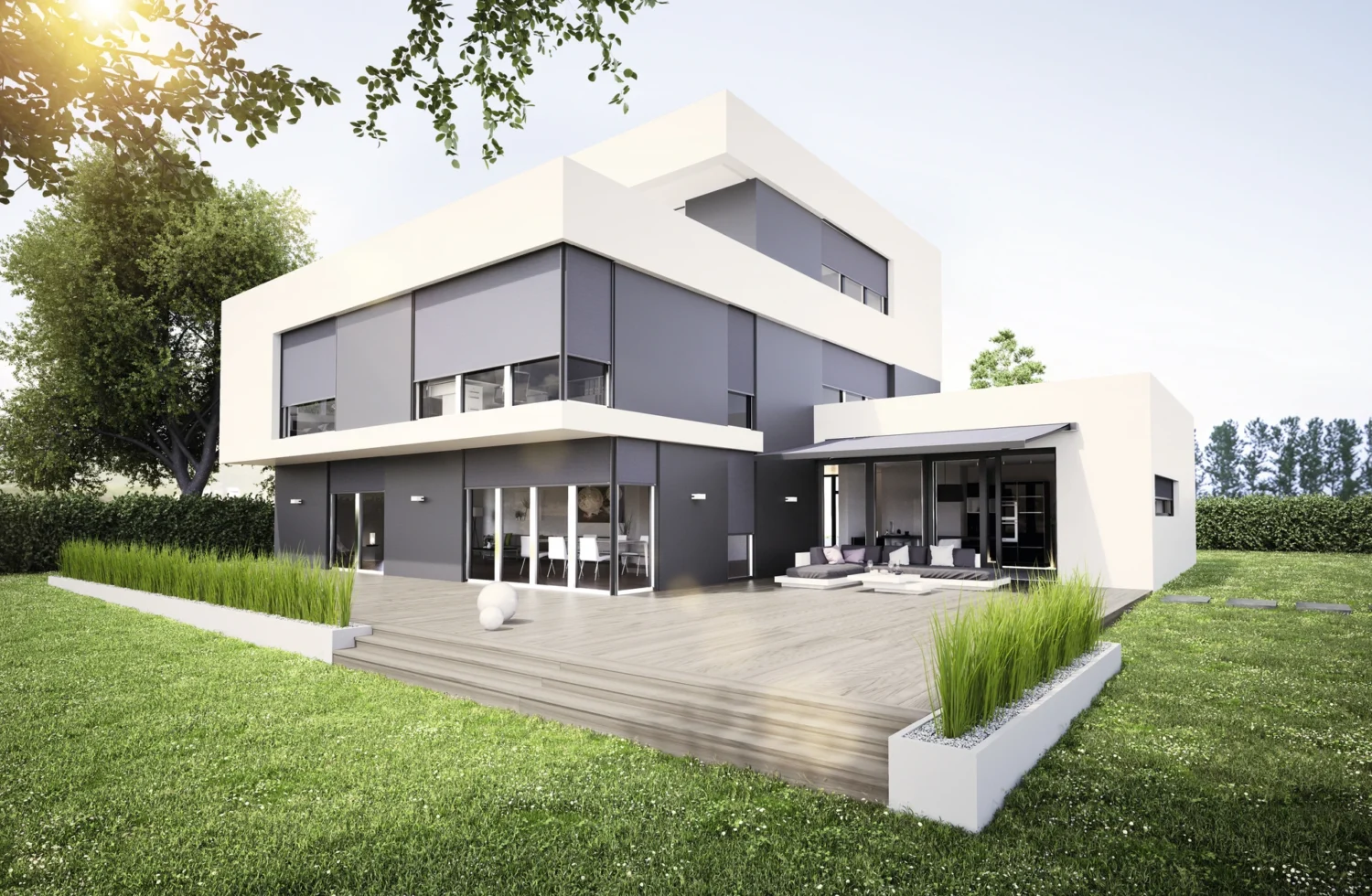 Modernes Architekturhaus mit großer Holzterrasse und Grünfläche bei Sonnenaufgang