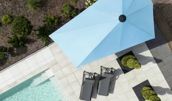 Luftaufnahme eines modernen Gartens mit Pool und blauem Sonnenschirm